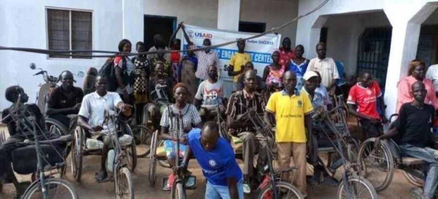 Community members with mobility aids and dignity kits at a DARD distribution
